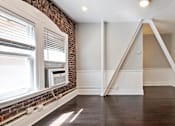 Thumbnail 3 of 51 - An apartment with a brick wall and a window with blinds at Brookmore Pasadena apartments.