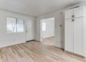 Thumbnail 7 of 43 - Fusion Fort Worth renovated one bedroom apartment in Haltom City, TX with light wood plank flooring, large white cabinets and double bedroom door.
