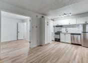 Thumbnail 3 of 43 - Fusion Fort Worth renovated apartment in Haltom City, TX with light wood plank flooring, stainless steel appliances, and subway tile backsplash.