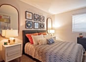 Thumbnail 12 of 25 - Large bedroom in the Canvas pet friendly apartments in Nashville, TN with large bed, midcentury modern nightstands and mirrors, and luxury carpet.