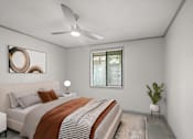 Thumbnail 9 of 36 - Retreat at Indian Lake Hendersonville TN apartments bedroom with a bed, a ceiling fan, and a plant.