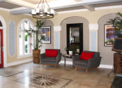 Thumbnail 24 of 29 - Pasadena Brookmore apartments lobby seating area with large gray midcentury chairs with red pillows on a marble tile floor.
