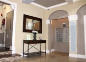 Thumbnail 26 of 29 - Pasadena Brookmore apartments lobby with tenant mailboxes and tall wall arches with decorative carved white trim.