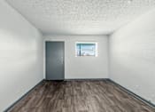 Thumbnail 7 of 27 - The Canvas Apartments Nashville living room with a grey door and a window with blinds.