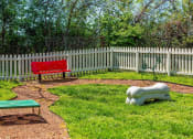 Thumbnail 27 of 49 - Pet park at the Retreat at Indian Lake apartment complex in hendersonville with red park bench and dog agility course equipment.