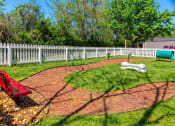 Thumbnail 26 of 49 - Pet park at the Retreat at Indian Lake apartment complex in hendersonville with dog agility course on a brown mulched track.
