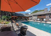 Thumbnail 12 of 37 - Fusion 35 pool area with a table and chairs under an orange umbrella.
