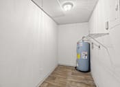 Thumbnail 12 of 36 - The Retreat at Indian Lake Apartments for rent in Hendersonville TN room with a grey water heater and wooden floor.