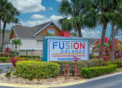 Thumbnail 45 of 60 - Fusion Orlando apartments street sign that reads "Furnished Residential Community" surrounded by tropical landscaping and palm trees.