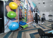 Thumbnail 30 of 60 - Fusion Orlando apartment fitness center with exercise balls, yoga mats, dumbbells, and cardio machines on modern herringbone floor.