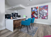Thumbnail 53 of 60 - Fusion Orlando apartments leasing office with pallet wood reception desk, two blue modern chairs, and a modern floral painting on two canvases.