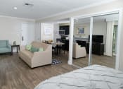 Thumbnail 15 of 60 - Fusion Orlando efficiency studio apartments Orlando, FL kitchen and spacious living room area with wood inspired plank flooring and large mirrored closet doors.