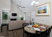 Thumbnail 12 of 60 - Fusion Orlando apartment living room view from kitchen with dinette breakfast nook set with four rustic colored placemats and white plates