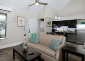 Thumbnail 10 of 60 - Fusion Orlando furnished studio apartment open concept kitchen and living area with in unit laundry and large window with vertical slat blinds.