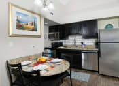 Thumbnail 7 of 60 - Fusion Orlando apartment in Orlando kitchen with dinette and stainless steel microwave, dishwasher, refrigerator, and electric stove.