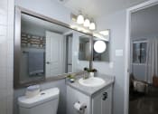 Thumbnail 16 of 43 - Fusion Fort Worth one bedroom apartment bathroom with single cabinet sink and chrome framed double mirror and medicine cabinet.