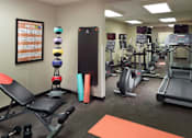 Thumbnail 12 of 18 - A fitness center with a variety of equipment including treadmills, weights, and exercise machines at Fusion Buckhead Apartments.