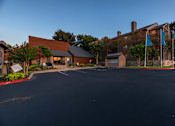 Thumbnail 20 of 37 - Fusion 35 parking lot in front of a building with blue flags to the right.