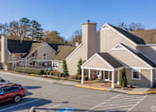 Thumbnail 14 of 18 - A red car is parked in a parking lot in front of a building at Fusion Buckhead Apartments.
