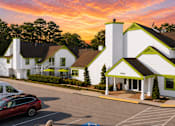Thumbnail 13 of 18 - A white building with green trim and a red car parked in front at Fusion Buckhead Apartments