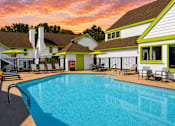 Thumbnail 8 of 18 - A swimming pool in front of Fusion Buckhead Apartments with a sunset in the background.