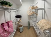 Thumbnail 7 of 36 - Fusion Crossroads walk-in closet with a pink bag hanging on the left.