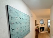 Thumbnail 6 of 36 - Fusion Crossroads hallway with a painting of animals on the wall looking into the living room.