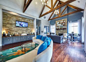 Thumbnail 21 of 32 - A resident clubhouse room with a stone wall and a glass coffee table at 1601 Eastchase Pkwy in Fort Worth, TX.
