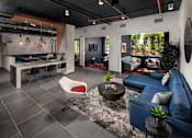 Thumbnail 18 of 24 - Fusion Encore Hollywood Apartments clubhousem with a blue couch and a white chair.