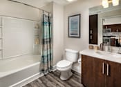 Thumbnail 7 of 24 - Fusion Encore Hollywood Apartments bathroom with a white tub, toilet, and sink.