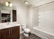 Thumbnail 11 of 24 - Fusion Encore Hollywood Apartments white bathroom with a white toilet, sink, and bathtub.