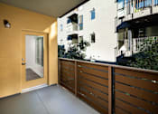 Thumbnail 5 of 24 - Fusion Encore Hollywood Apartments with private balcony with a wooden railing and a glass door leading to a building.