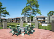 Thumbnail 25 of 43 - Outdoor seating at Fusion Fort Worth apartments in Haltom City, TX with green Adirondack chairs around a gas fire pit
