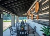 Thumbnail 21 of 43 - outdoor seating area at Fusion Fort Worth Apartment complex in Haltom City, Texas with modern greyscale siding and black metal patio furniture