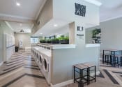 Thumbnail 42 of 43 - on-site laundry room in fusion Fort Worth apartments with herringbone flooring and large waiting area