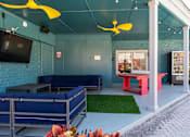 Thumbnail 31 of 41 - A blue couch and a red table are in front of a blue wall at the Fusion Orlando apartments.