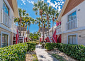 Thumbnail 38 of 41 - A sunny day at a residential area with palm trees and apartment buildings.
