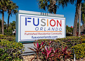 Thumbnail 33 of 41 - A sign for Fusion Orlando, a furnished residential community, is displayed in front of some trees.
