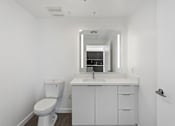 Thumbnail 20 of 52 - Fusion Hollywood white bathroom with a toilet, sink, and mirror.
