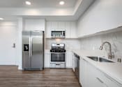 Thumbnail 7 of 52 - Fusion Hollywood Apartments modern kitchen with a stainless steel refrigerator, stove, and oven.