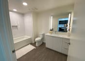 Thumbnail 4 of 18 - Apartments on Hollywood Blvd Los Angeles with white bathroom with a toilet, sink, and bathtub.