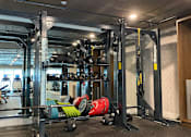 Thumbnail 6 of 18 - Fusion Hollywood Apartments gym with a weight rack and weights on the floor.