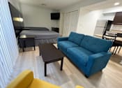 Thumbnail 24 of 60 - a living room with a couch and a table and a bed