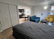 Thumbnail 25 of 60 - a bedroom and living room with a couch and a bed