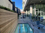 Thumbnail 11 of 18 - Fusion Hollywood apartments with hot tub jacuzzi spa with a metal railing is surrounded by a wooden fence.
