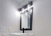 Thumbnail 4 of 36 - Retreat at Indian Lake apartments in Hendersonville, TN white bathroom vanity with a marble top and a mirror above it.