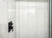 Thumbnail 5 of 36 - Retreat at Indian Lake apartments in Hendersonville, TN white tiled shower with a black shower head.