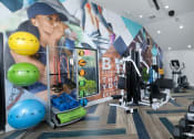 Thumbnail 29 of 60 - Fusion Orlando apartment fitness center with bodyweight equipment, cardio machines, and weight training equipment.