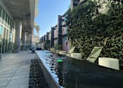 Thumbnail 16 of 18 - Apartments at 5750 Hollywood Blvd, Los Angeles, CA 90028 long black bench with a water feature in the middle.