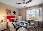 Thumbnail 10 of 36 - Bedroom in Stadium 700 Apartments near UTA - 2 bedroom apartments in Arlington, TX with large window, ceiling fan, and luxury carpet